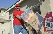 Man moving a cart with a box and tote on it