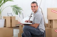Smiling moving man surrounded by boxes