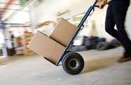 Person pushing a moving cart with boxes on it